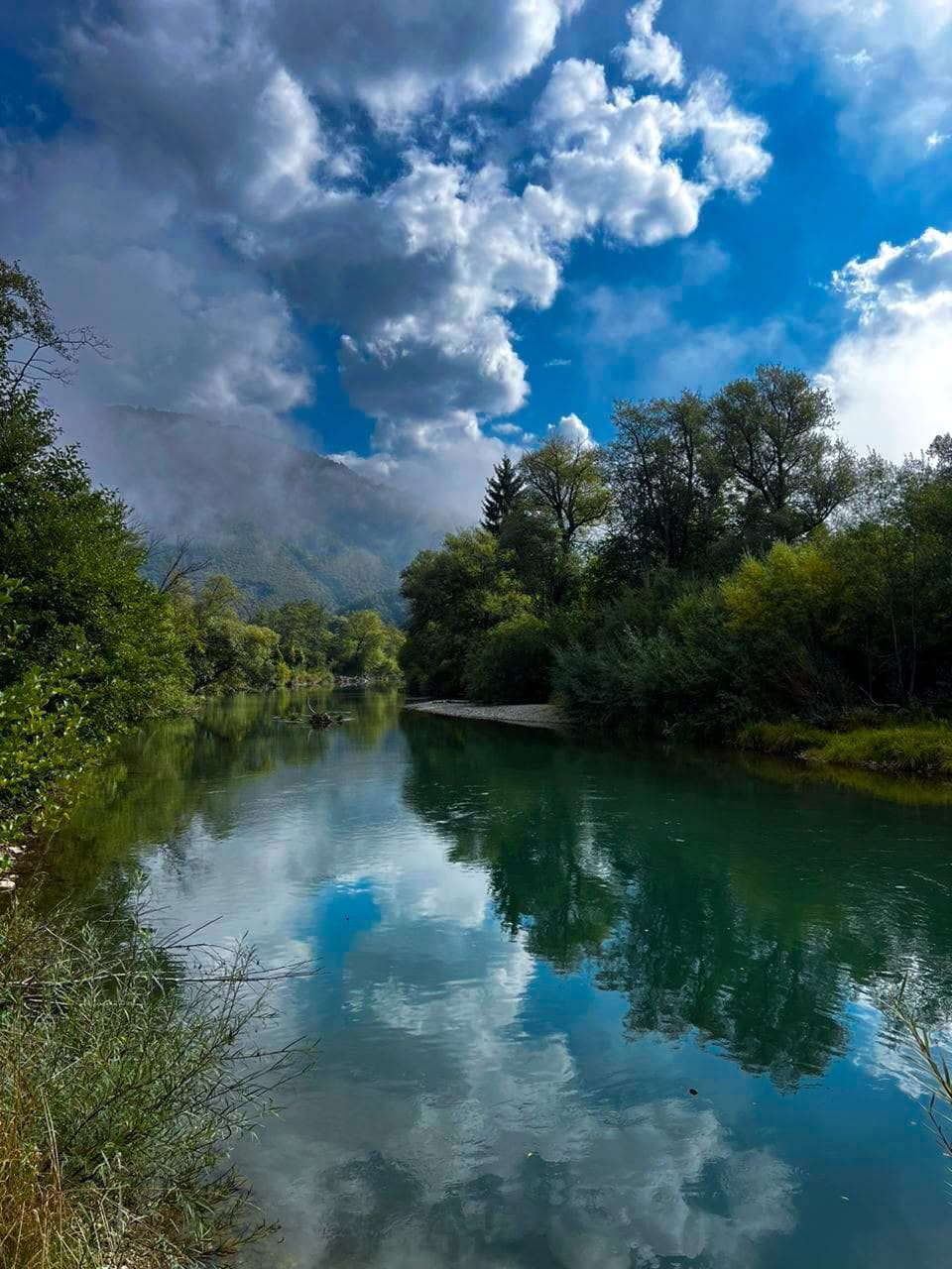 Clouds mirrored on a slow, clear pool